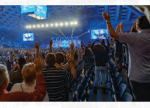Audience with raised hands facing the stage 